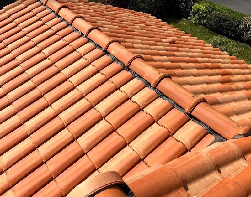 Couverture neuve en tuiles canal avec faîtage à sec ventilé, vue rapprochée d’un toit refait